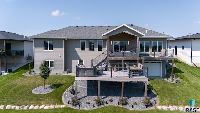 rear view of property with a garage, a deck, and a lawn