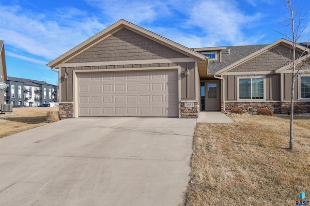 craftsman house with a garage, a front lawn, and central air condition unit