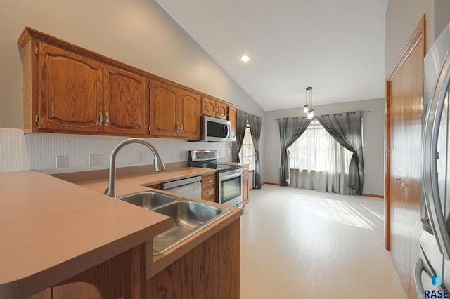 kitchen featuring vaulted ceiling, appliances with stainless steel finishes, kitchen peninsula, and decorative light fixtures