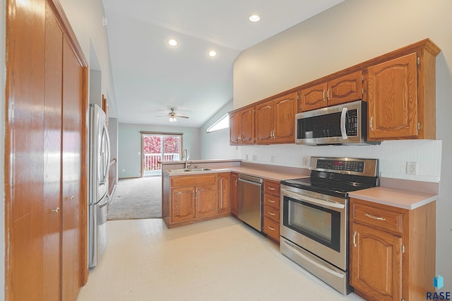 kitchen with vaulted ceiling, appliances with stainless steel finishes, tasteful backsplash, sink, and kitchen peninsula