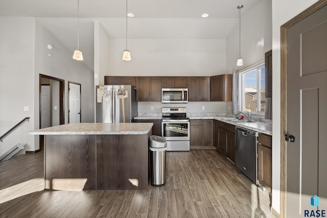 kitchen with dark wood-type flooring, sink, high vaulted ceiling, pendant lighting, and stainless steel appliances