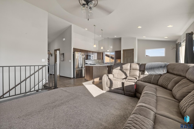 living room with ceiling fan, lofted ceiling, and dark colored carpet