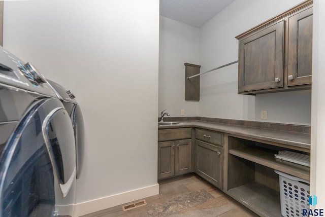 laundry room with cabinets, sink, and independent washer and dryer