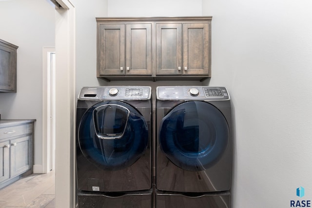 laundry room featuring cabinets and washing machine and clothes dryer