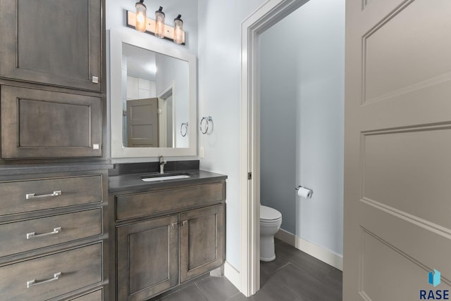 bathroom featuring tile patterned flooring, vanity, and toilet