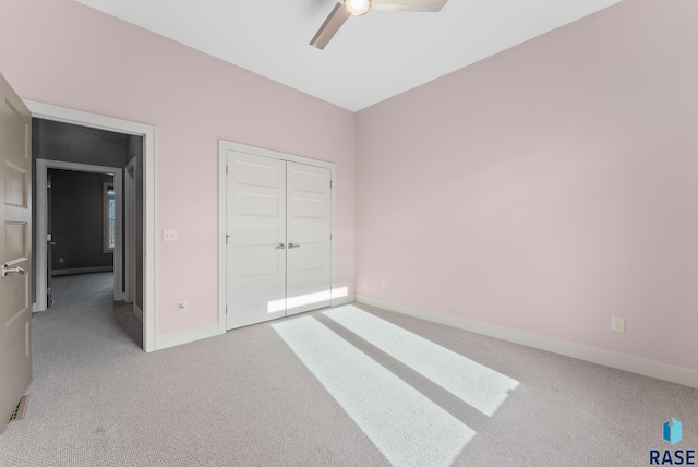 unfurnished bedroom featuring ceiling fan, a closet, and light carpet