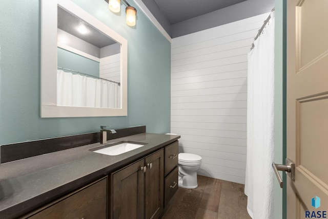 bathroom featuring vanity, wood-type flooring, and toilet