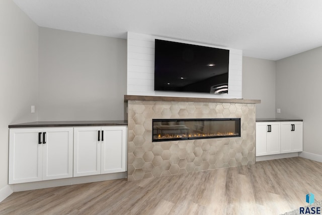 unfurnished living room featuring a fireplace and light hardwood / wood-style flooring