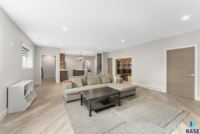 living room featuring light hardwood / wood-style flooring and a chandelier