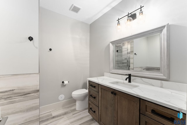 bathroom featuring vanity, hardwood / wood-style floors, and toilet