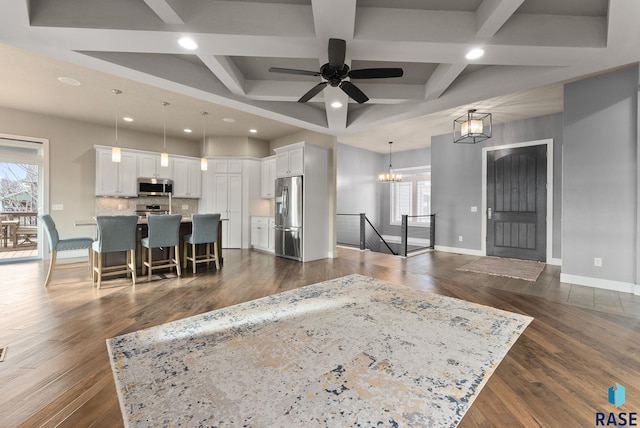 living room featuring a healthy amount of sunlight, dark hardwood / wood-style floors, and beam ceiling