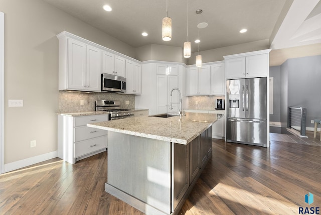 kitchen with white cabinetry, sink, stainless steel appliances, and a center island with sink