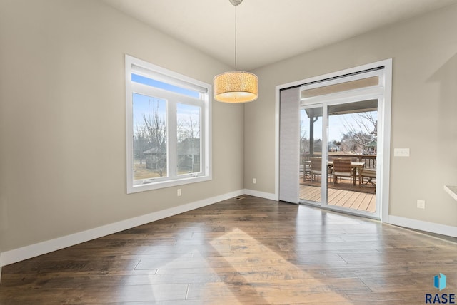 unfurnished dining area featuring dark wood-type flooring