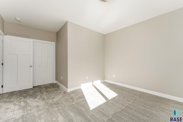 unfurnished bedroom with a closet and light carpet