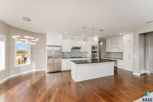 kitchen with a kitchen island, appliances with stainless steel finishes, pendant lighting, and white cabinets