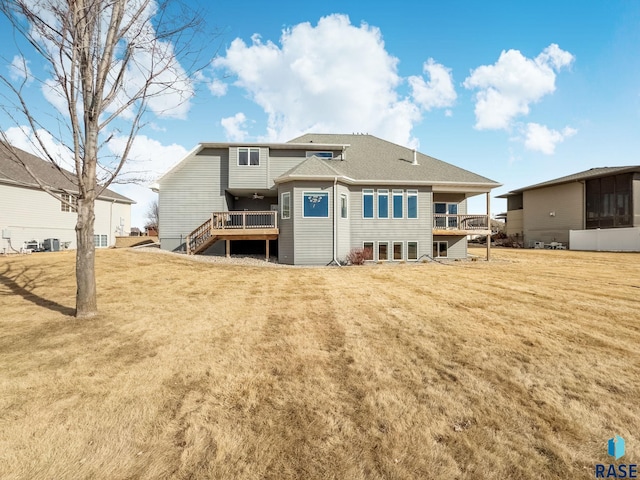 back of house featuring a wooden deck and a lawn