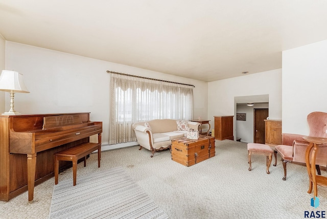 sitting room featuring light colored carpet and a baseboard heating unit