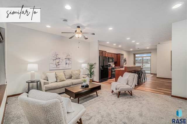 carpeted living room with ceiling fan