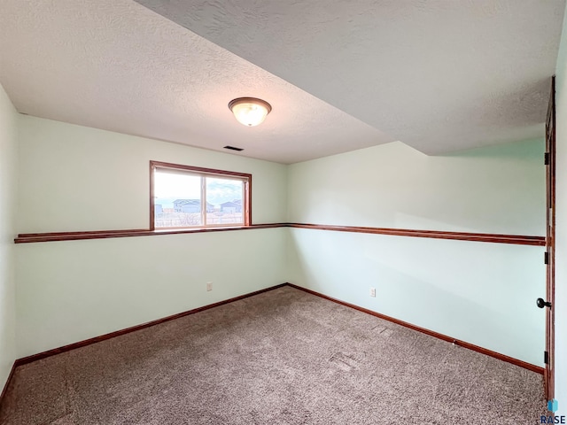 spare room with carpet floors and a textured ceiling