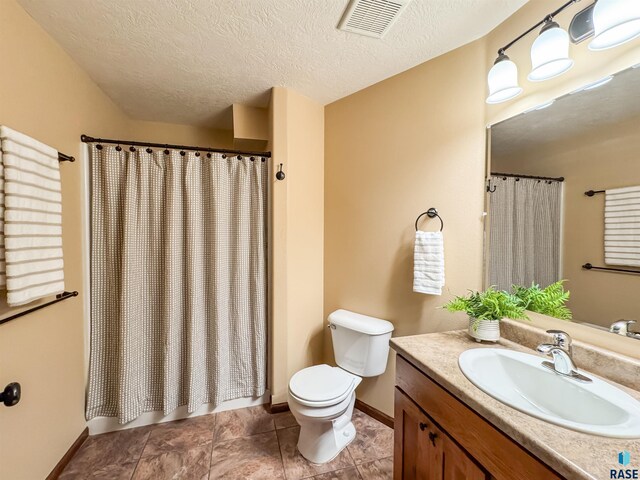 bathroom with vanity, a textured ceiling, and toilet