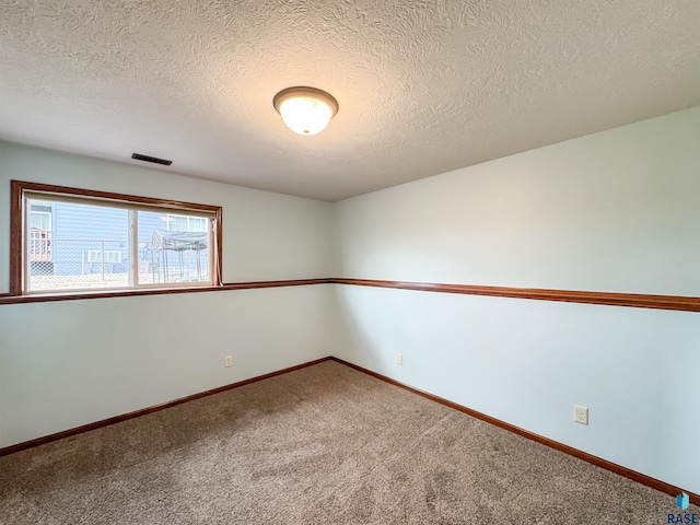 unfurnished room featuring carpet floors and a textured ceiling