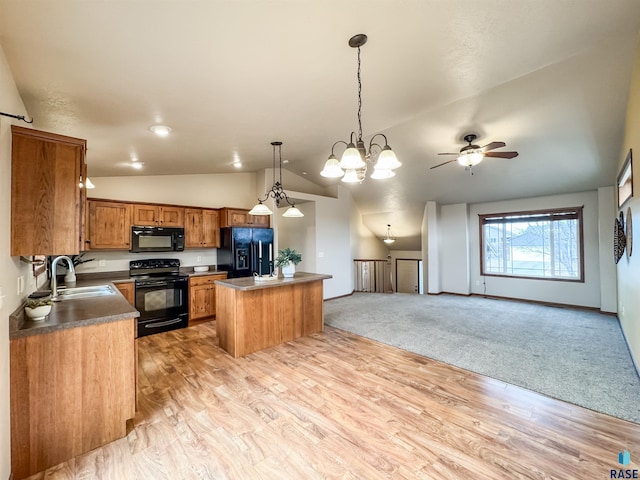 kitchen with sink, decorative light fixtures, a kitchen island, ceiling fan with notable chandelier, and black appliances