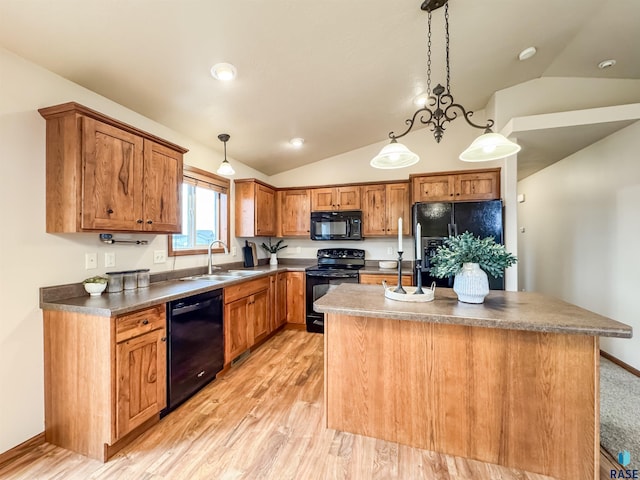 kitchen with lofted ceiling, sink, hanging light fixtures, black appliances, and a kitchen island