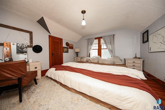 bedroom with vaulted ceiling and a textured ceiling