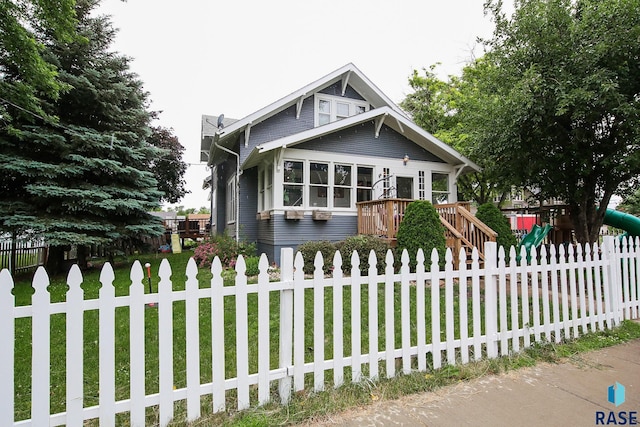 view of front of property with a front lawn and a playground