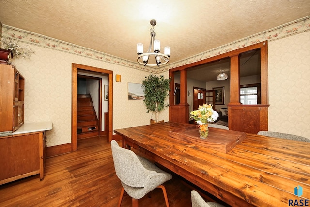 dining area with hardwood / wood-style flooring, an inviting chandelier, and a textured ceiling