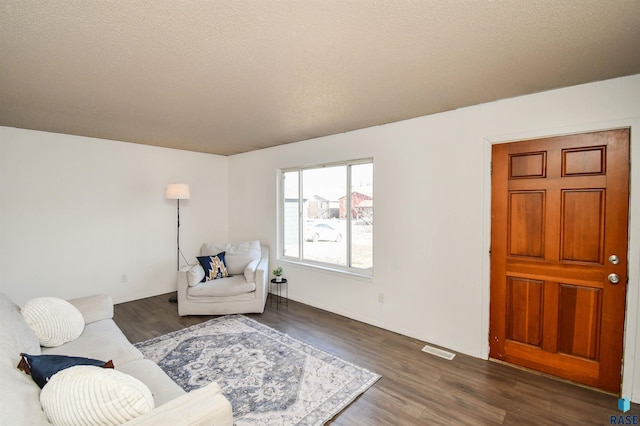 living room with dark wood-type flooring and a textured ceiling