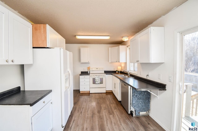 kitchen with white cabinetry, sink, and white appliances