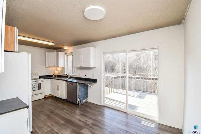 kitchen with sink, white appliances, a textured ceiling, and white cabinets