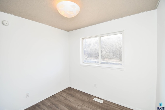 empty room featuring dark wood-type flooring