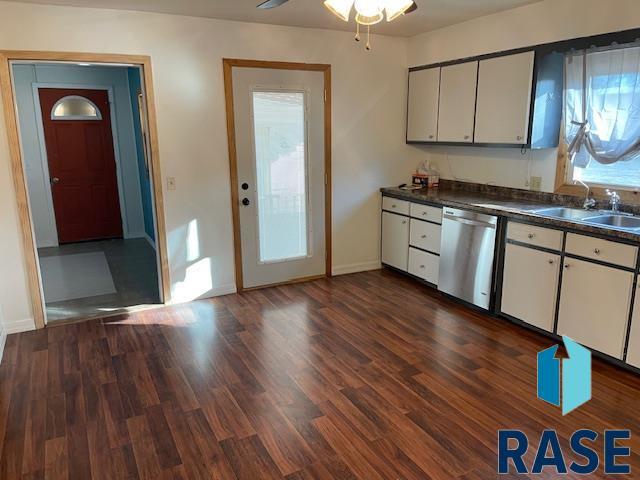 kitchen with sink, stainless steel dishwasher, dark hardwood / wood-style floors, ceiling fan, and white cabinets