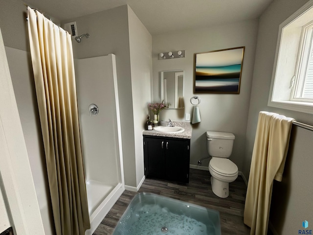 bathroom with hardwood / wood-style flooring, vanity, toilet, and walk in shower