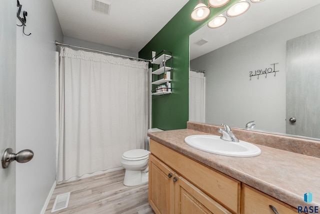 bathroom featuring vanity, wood-type flooring, and toilet