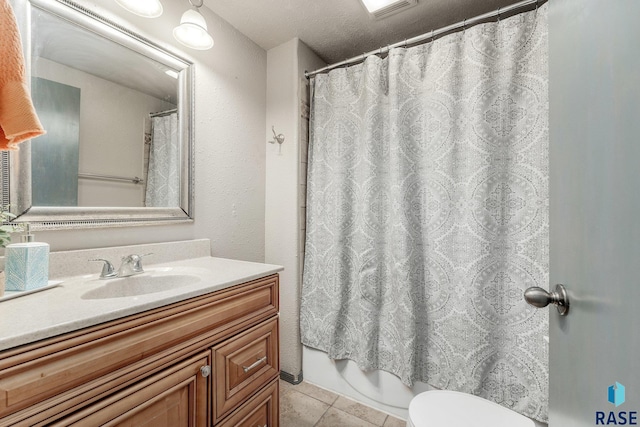 bathroom with curtained shower, vanity, toilet, tile patterned floors, and a textured ceiling