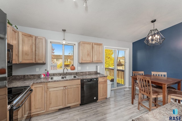 kitchen with sink, light hardwood / wood-style flooring, plenty of natural light, black appliances, and decorative light fixtures