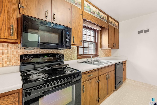 kitchen featuring backsplash, light tile patterned floors, sink, and black appliances