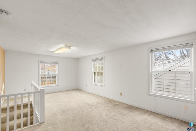 carpeted empty room with plenty of natural light