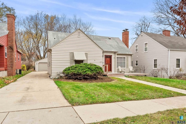 view of front of property with cooling unit, a garage, an outdoor structure, and a front lawn