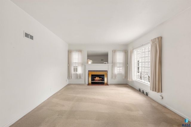 unfurnished living room featuring a brick fireplace and light carpet