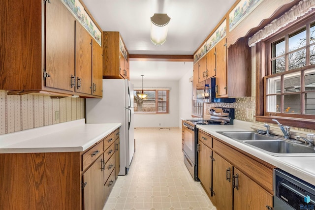 kitchen with stainless steel appliances, sink, and hanging light fixtures