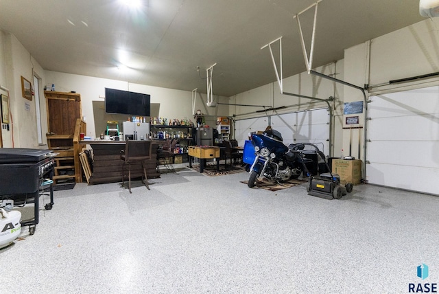 garage with stainless steel fridge with ice dispenser