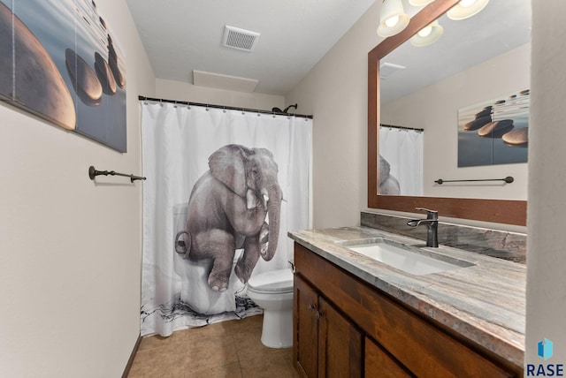 bathroom with tile patterned flooring, vanity, and toilet