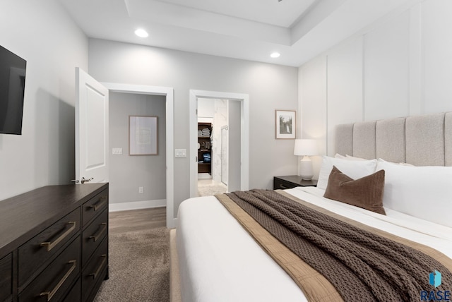 bedroom with a tray ceiling and dark hardwood / wood-style flooring