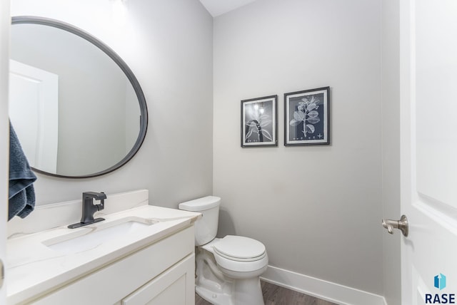 bathroom featuring vanity, hardwood / wood-style floors, and toilet