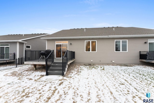 snow covered house with a deck