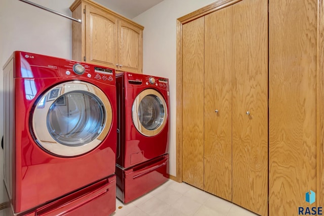 washroom with cabinets and washer and dryer